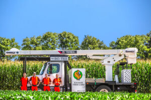 The Kansas Tree Care team standing proudly with their tree service truck and equipment in Lawrence, KS.