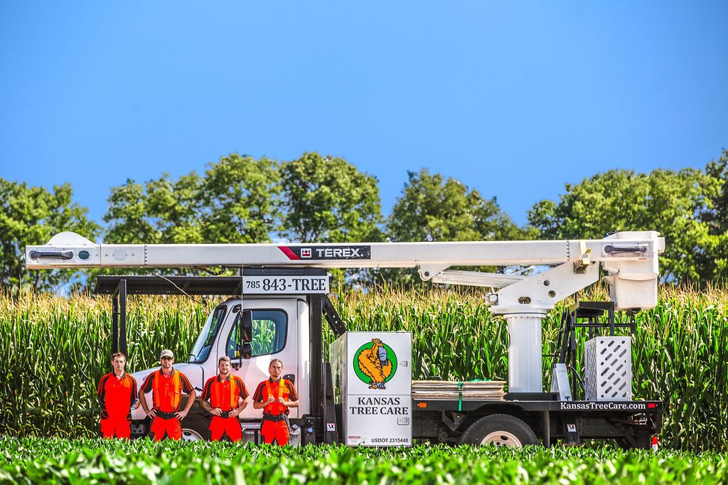 The Kansas Tree Care team standing proudly with their tree service truck and equipment in Lawrence, KS.
