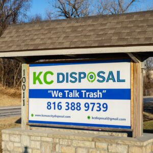 Rear view of a bright green KC Disposal garbage truck, showing its branding in Kansas City, KS.