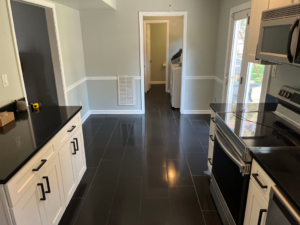 A renovated kitchen area leading to a hallway with new wainscoting and fresh paint by Precision Home Improvement in Virginia Beach, VA.