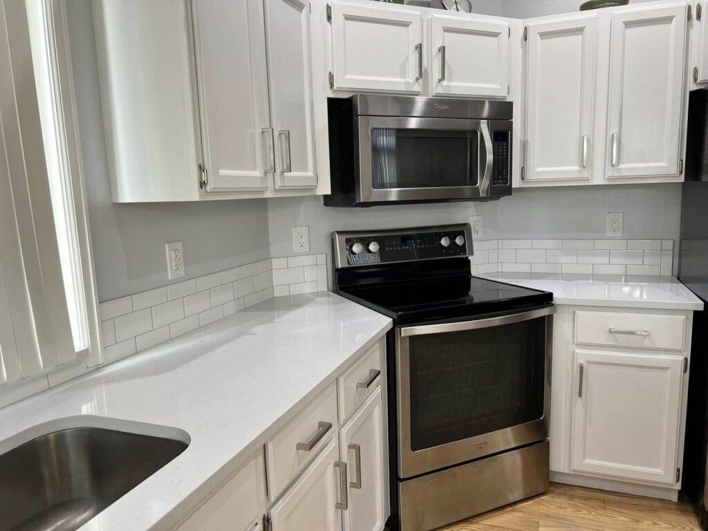 A modern kitchen with new stainless steel appliances and subway tile backsplash installed by Blue Collar Service Pros in Aurora, CO.