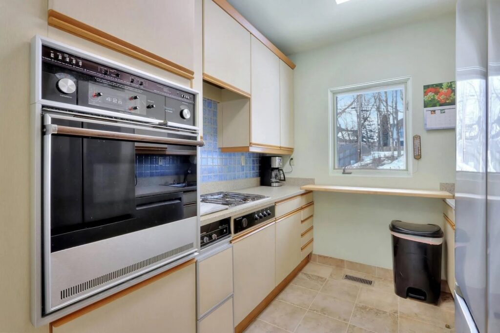 A kitchen with older built-in appliances and cabinets, before renovation by Infinity Handyman in Anchorage, AK