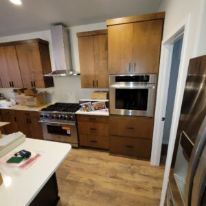 A kitchen featuring newly installed range hood, stove, and built-in oven with matching cabinetry by Amazing Handyman Services in West Fargo, ND