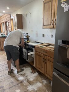 A handyman installing a kitchen appliance into cabinetry for Northeast SD Handyman in Watertown, SD.
