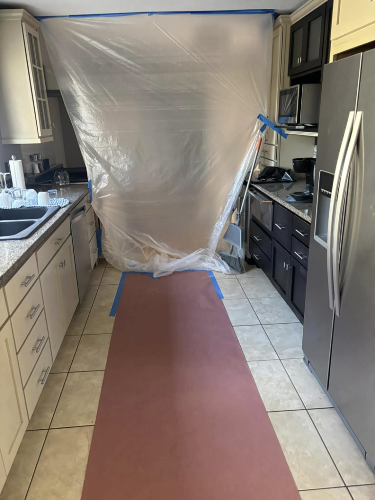 A kitchen area taped off and protected for cabinet painting or refinishing by Considerate Repair in Walla Walla, WA.