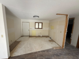 A kitchen area undergoing renovation with walls stripped and subfloor exposed by A&B Snow, Mow, and Contracting in Sioux City, IA.
