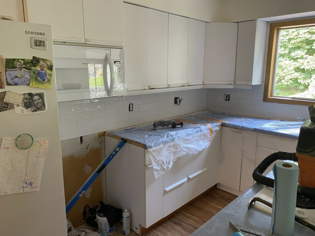Preparing kitchen countertops and installing a new backsplash during a remodel by Berg Handyman Services in Post Falls, ID