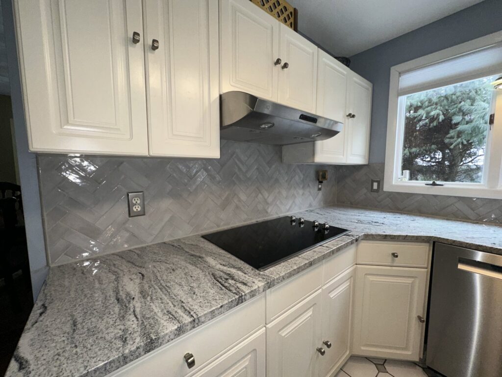 A newly renovated kitchen featuring a herringbone tile backsplash and new countertops installed by R&J Handyman Services LLC in Warwick, RI.