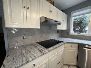 A newly renovated kitchen featuring a herringbone tile backsplash and new countertops installed by R&J Handyman Services LLC in Warwick, RI.
