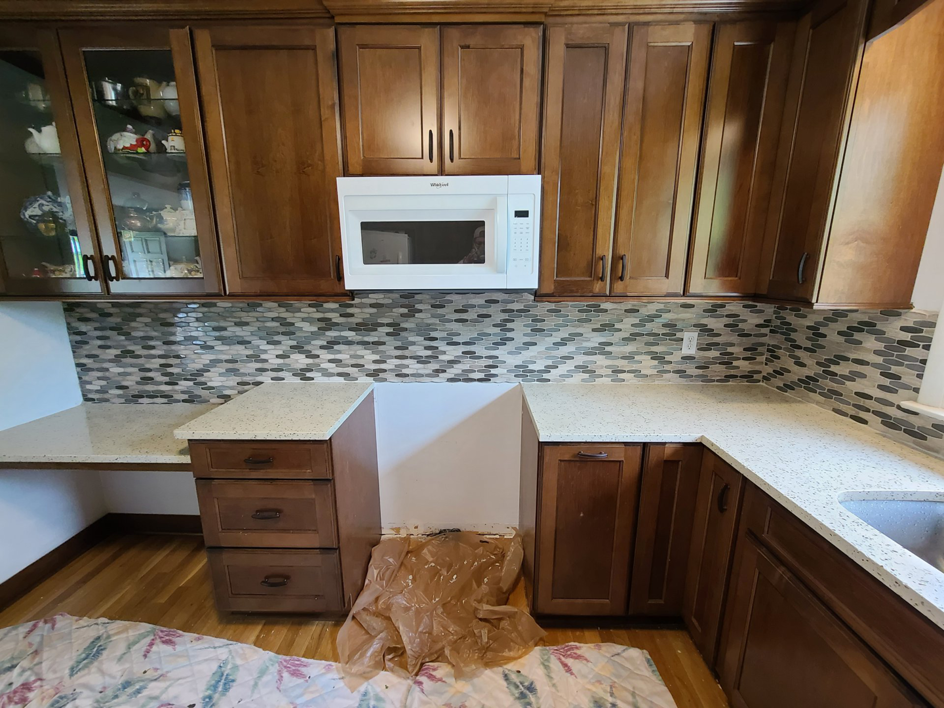 A kitchen renovation showcasing new backsplash, quartz countertops, and an installed microwave by J & J Home Improvements, LLC in Franklin, TN.