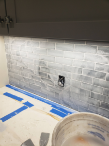 Close-up of a kitchen backsplash being grouted during a renovation by BEST QUALITY CONSTRUCTION COMPANY in Fountain Valley, CA.