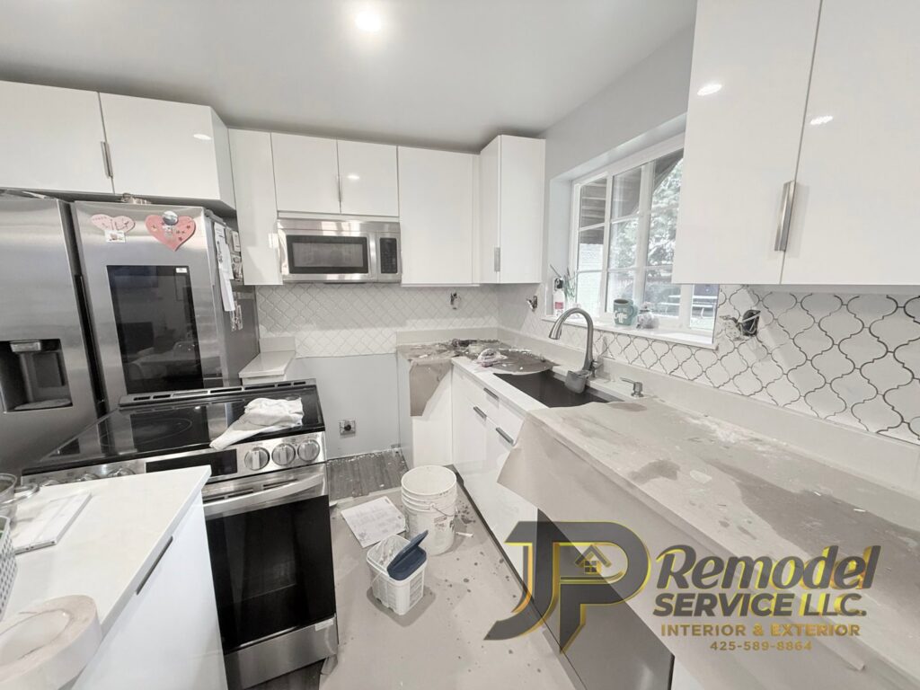 A kitchen remodel in progress, showing white cabinets and a new backsplash being installed by JP. Remodel Service LLC in Everett, WA.