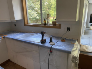 Installing a new kitchen backsplash with tools and protected countertops by Berg Handyman Services in Post Falls, ID