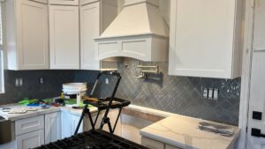 Kitchen backsplash installation in progress with new cabinets and range hood by Sal Handyman Services in Canyon Country, CA