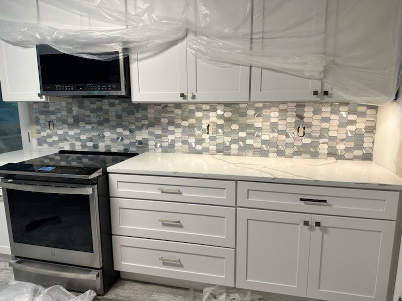 New kitchen backsplash installation with white cabinets, a service by Quality Services, LLC in Alexandria, VA.