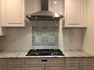 Kitchen backsplash and range hood installation by Northeast Building Services LLC, Boston, MA. Subway tiles and decorative pattern.