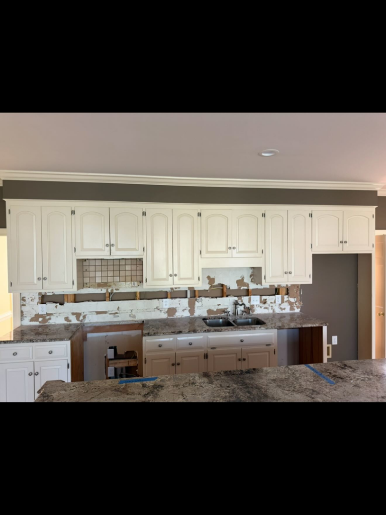 A kitchen undergoing renovation with the backsplash removed and wall damage visible by Rice Building Company in Rocky Mount, NC.