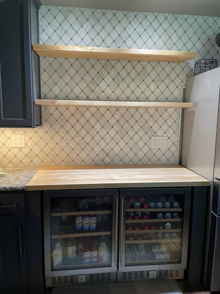 Kitchen area with new tile backsplash, floating wooden shelves, and beverage coolers installed by Absolute Integrity Handyman Services Inc in Fresno, CA.