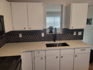 A modern kitchen with a new hexagonal tile backsplash, sink, and faucet installed by Joe Norton's Handyman Service in Williston, ND.