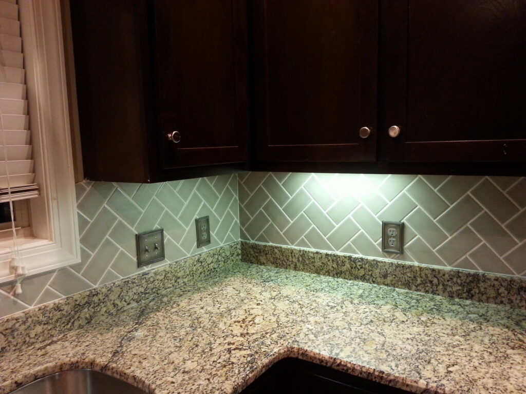 New kitchen backsplash with herringbone subway tiles and under-cabinet lighting by Rapid Repairs and Renovations in Knoxville, TN.