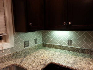 New kitchen backsplash with herringbone subway tiles and under-cabinet lighting by Rapid Repairs and Renovations in Knoxville, TN.