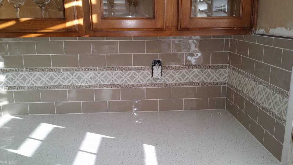 Close-up of a kitchen backsplash with new tile and decorative border installed by Gudiño's Tile and Natural Stone in Glendale, AZ