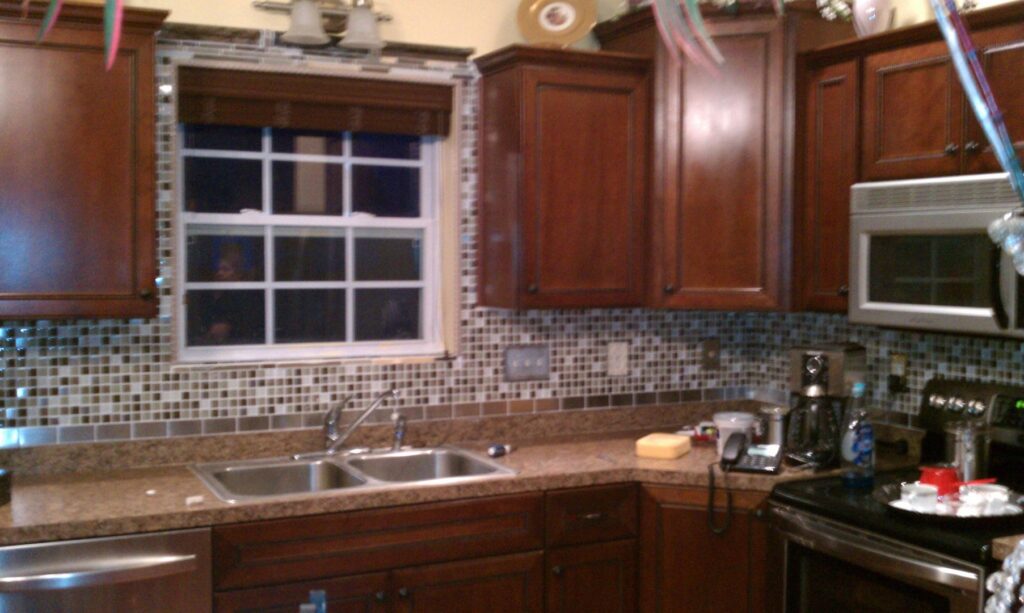 A newly installed tiled kitchen backsplash and cabinetry by Amazing Handyman Services in West Fargo, ND