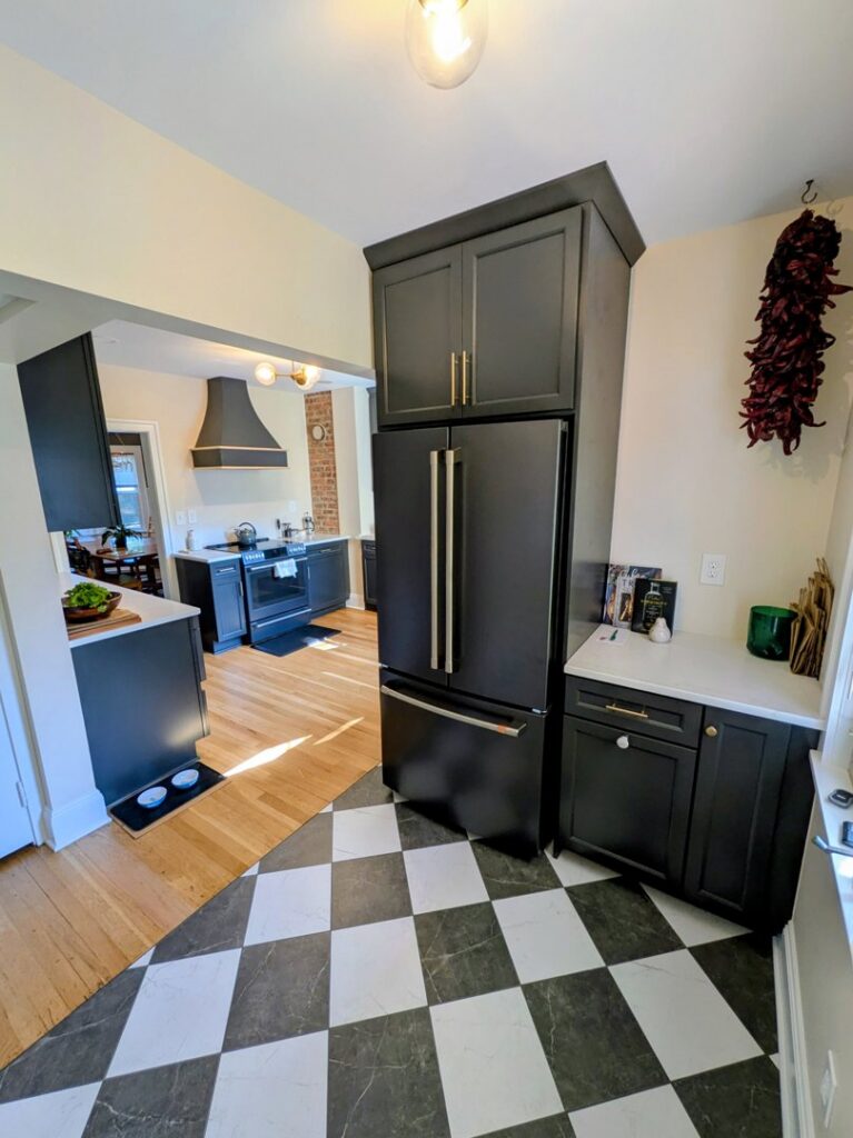 A remodeled kitchen featuring a striking black and white checkered floor and dark cabinets by CLE Remodeling Co in Cleveland, OH.