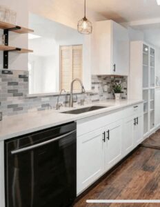 A kitchen with newly installed white cabinets, a stylish backsplash, and a dishwasher by The Sioux Falls Handyman in Sioux Falls, SD.