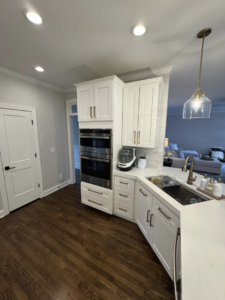 A modern kitchen featuring white cabinets and built-in double ovens installed by Branch Home Improvement LLC in Raleigh, NC.