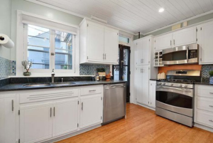 A kitchen with white cabinets, blue mosaic backsplash, and new appliances installed by Scott Hall Remodeling in Columbus, OH.
