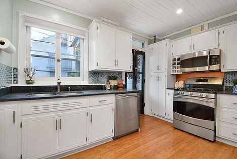 A kitchen with white cabinets, blue mosaic backsplash, and new appliances installed by Scott Hall Remodeling in Columbus, OH.