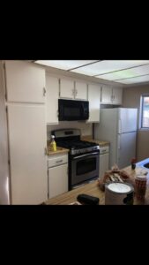 A kitchen with updated white cabinets and appliances, showcasing renovation services by Mancusi Home Maintenance in Boulder City, NV.