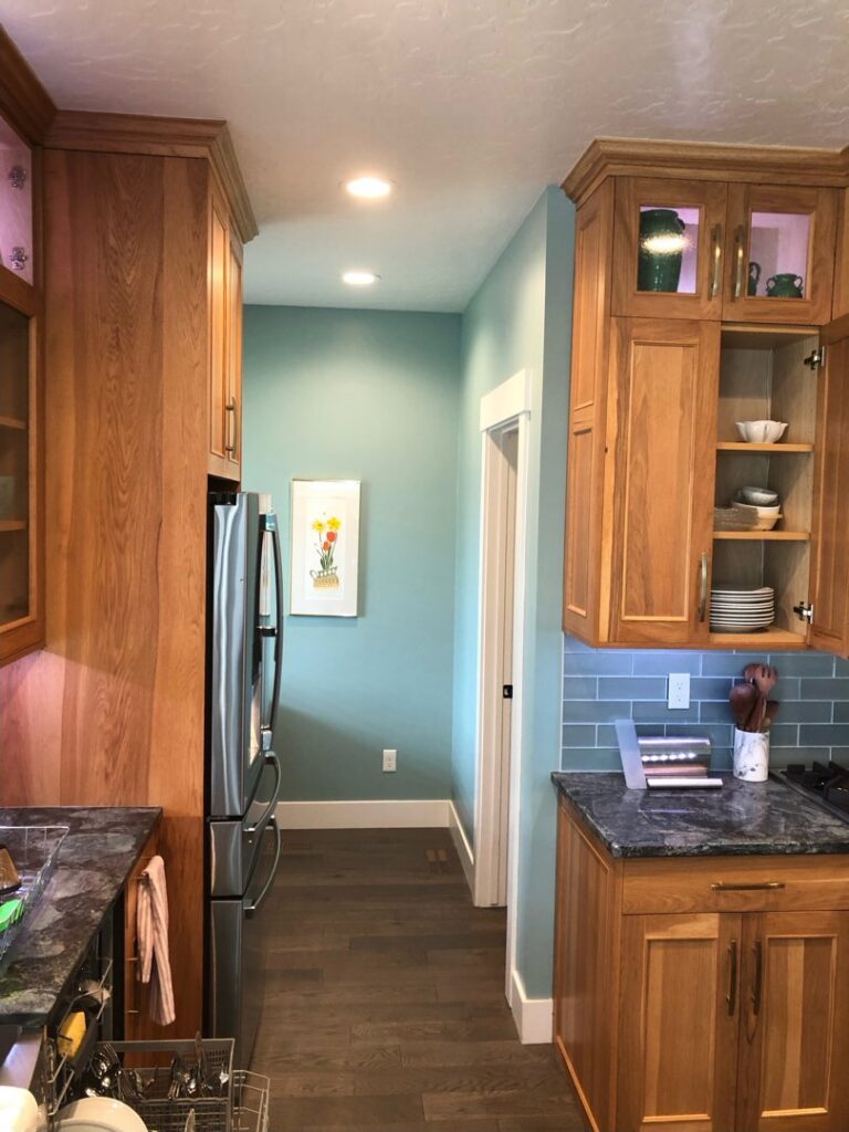 Kitchen hallway featuring new wooden cabinets and blue subway tile backsplash installed by The Huckleberry Handyman in Meridian, ID.