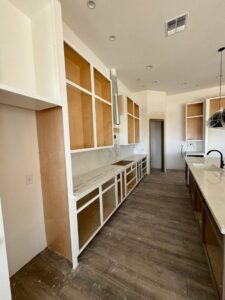 A kitchen under construction, showing cabinet frames and countertops being installed by Kelso Custom Builders, Inc. in Phoenix, AZ.