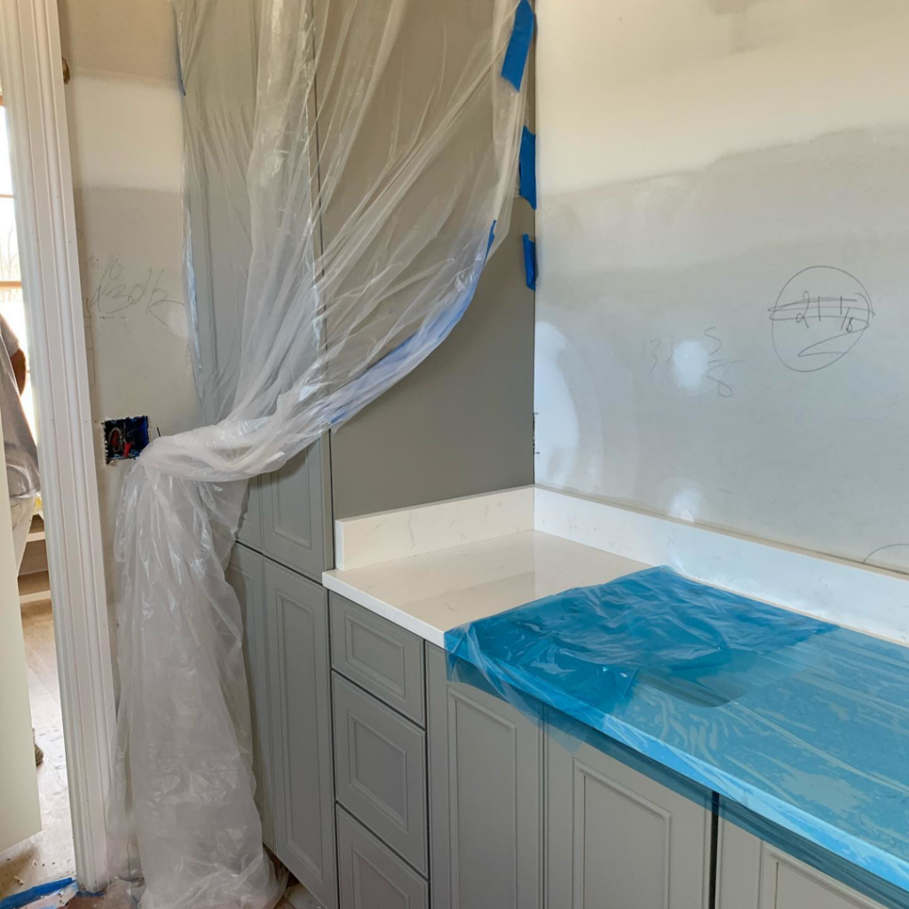 Kitchen cabinets and countertops being installed with protective plastic sheeting during a handyman renovation by Mike Murphy Builders, LLC in Memphis, TN.