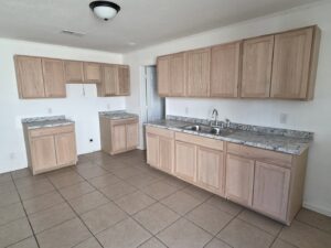 A kitchen with newly installed cabinets and countertops, awaiting appliances, completed by SMM Services LLC in Gulfport, MS.