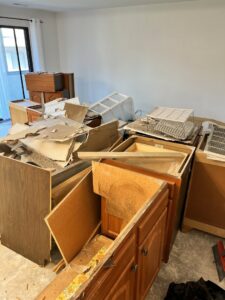 A large pile of old kitchen cabinets and demolition debris in a home, ready for junk removal by Pack N Haul in West Valley City, UT.