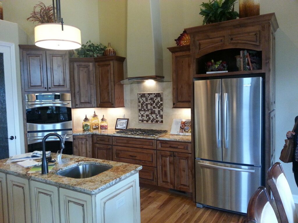 A newly installed kitchen with dark wood cabinets, stainless steel appliances, and a granite island by Advanced Remodeling Services in Elbert, CO.