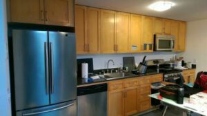 A bright kitchen featuring new wooden cabinets and stainless steel appliances by Barry's Handyman Service in San Diego, CA.