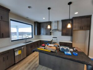 Kitchen cabinet and appliance installation in progress with tools on the island by Woods Builders in Grand Rapids, MI.