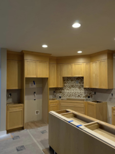 Kitchen cabinet installation in progress by Restore Renew Remodel in Portland, OR, showing new light wood cabinets.