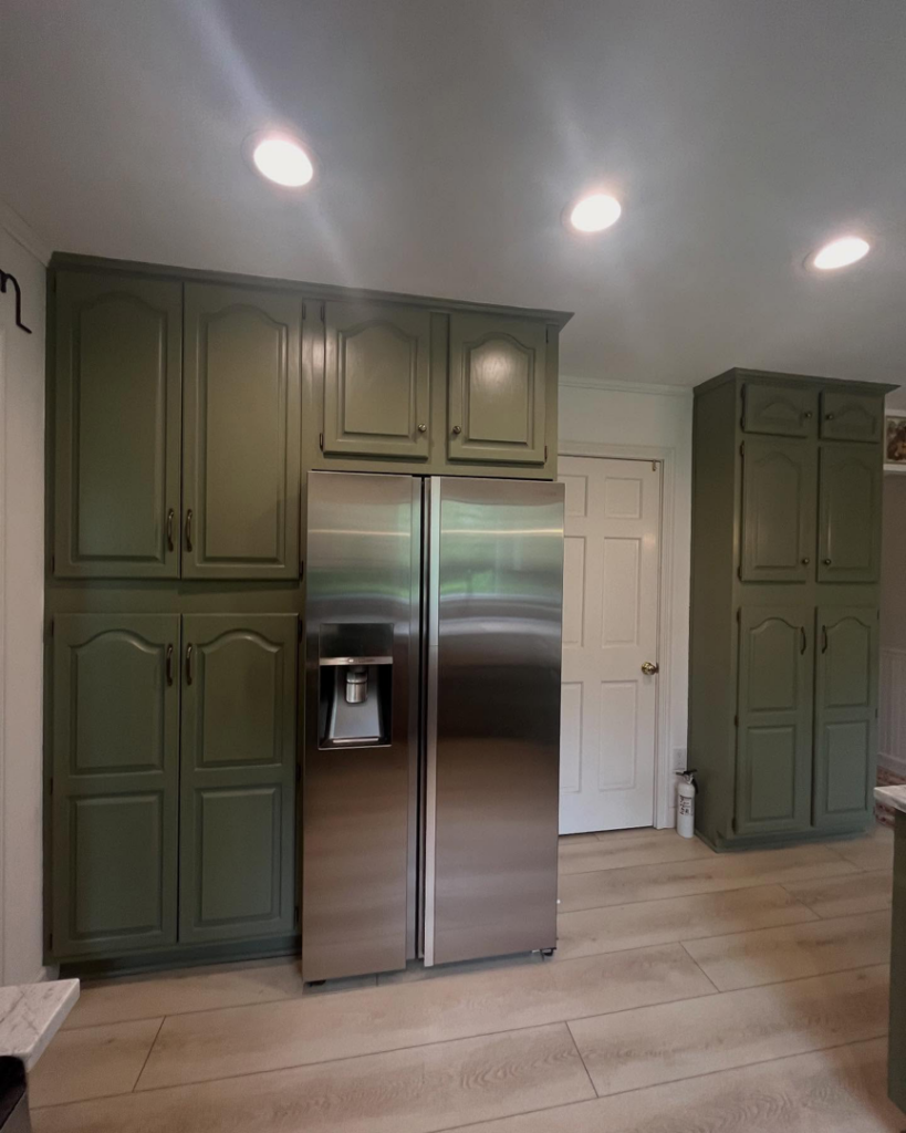 Kitchen with newly installed green cabinets and stainless steel refrigerator by True North Builders in Franktown, CO.