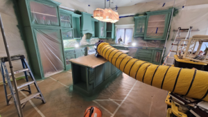 A kitchen undergoing cabinet painting and renovation by Acosta Painting LLC in Jonesboro, AR, with surfaces protected.