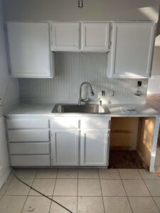A kitchen with freshly painted white cabinets and a new sink installation, completed by FES handyman services LLC in Boise, ID.