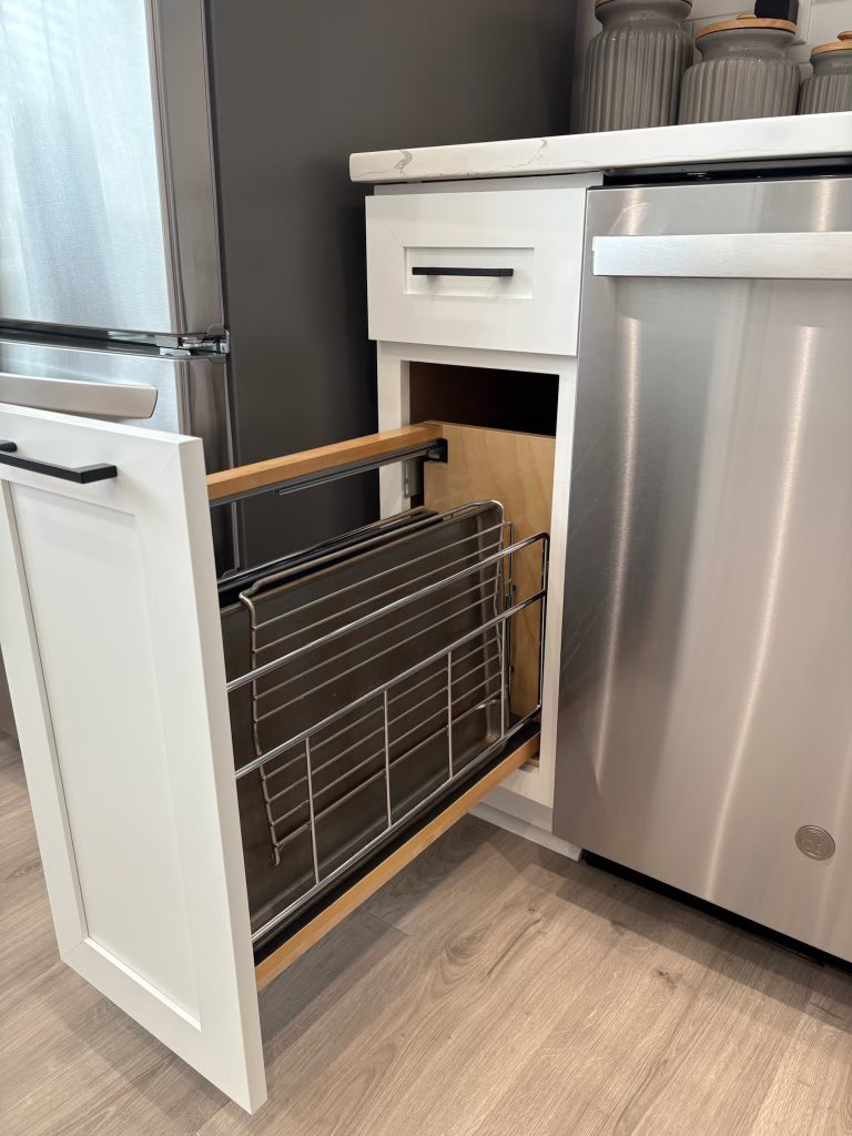A kitchen cabinet with a convenient pull-out rack for baking sheets, installed by Cincinnati Cabinet Refacing in Cincinnati, OH.