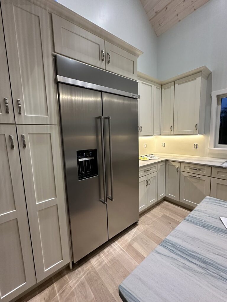A modern kitchen with new cabinets and a large stainless steel refrigerator installed by R&J Handyman Services LLC in Warwick, RI.