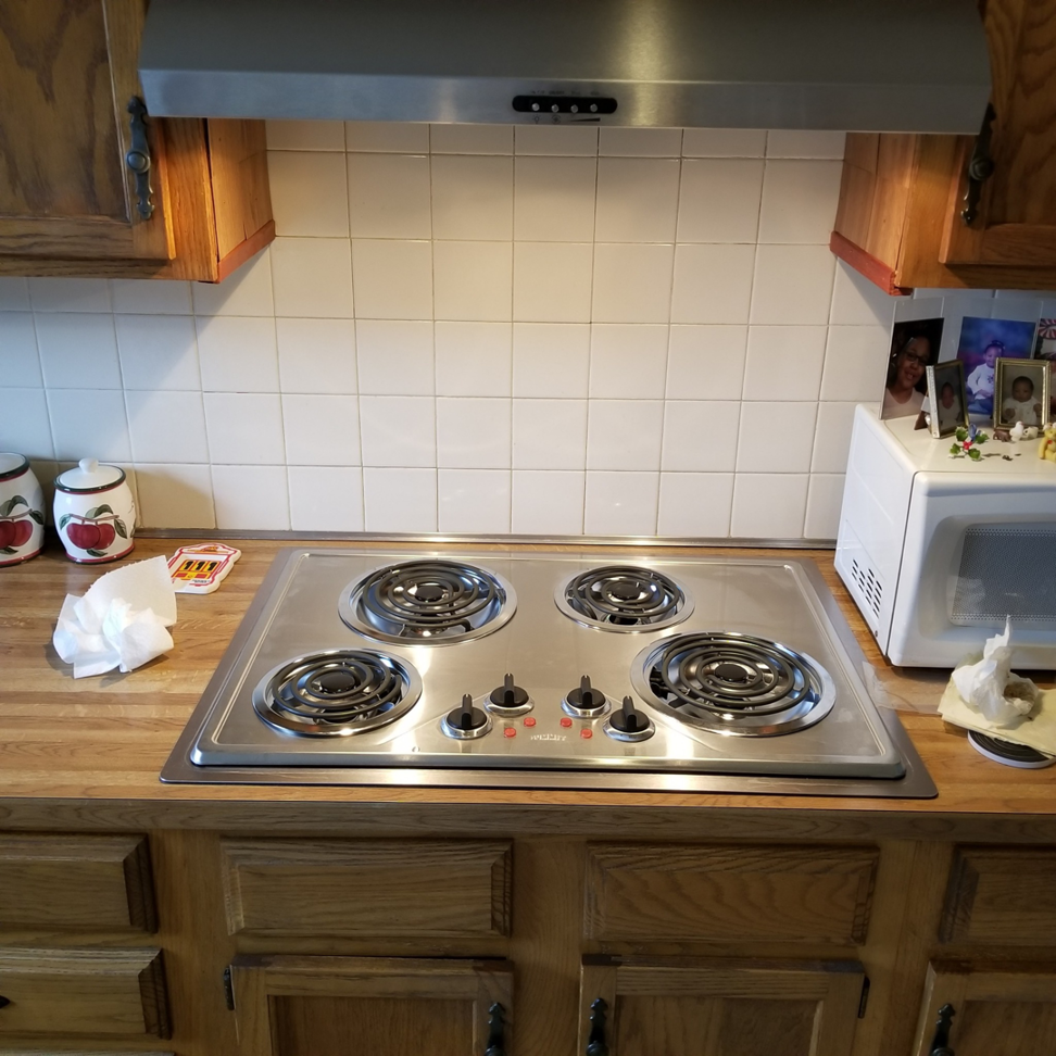 A newly installed electric coil cooktop and range hood in a kitchen, a service provided by Paul's Handyman Solutions in Lexington, KY.
