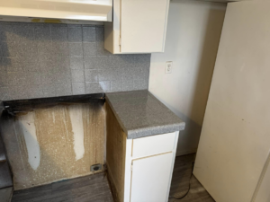 A kitchen corner with a newly resurfaced grey speckled countertop and backsplash by That Resurfacing Guy LLC in Oklahoma City, OK.
