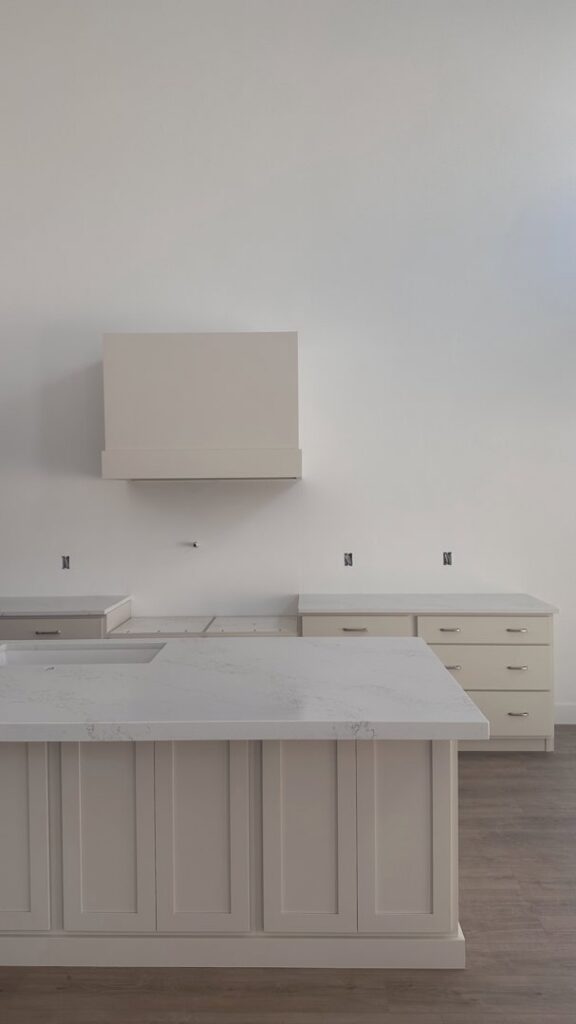 A kitchen with new white granite countertops and cabinets being installed by Victor's Granite Counter-Tops in Millcreek, UT.